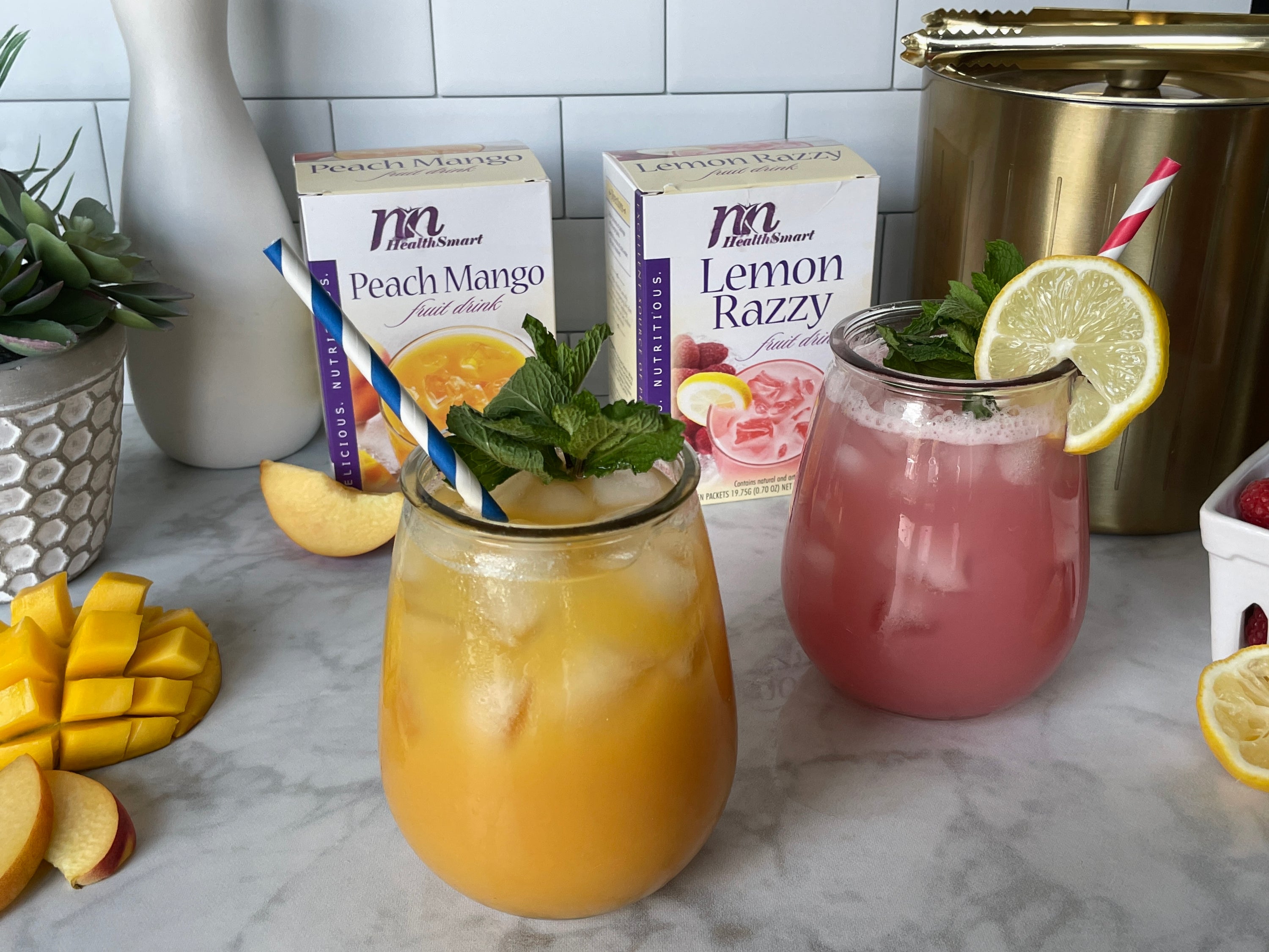 Two summer mocktails using Nashua Nutrition high protein fruit drink mixes. Layed out nicely with products and mocktail side by side.